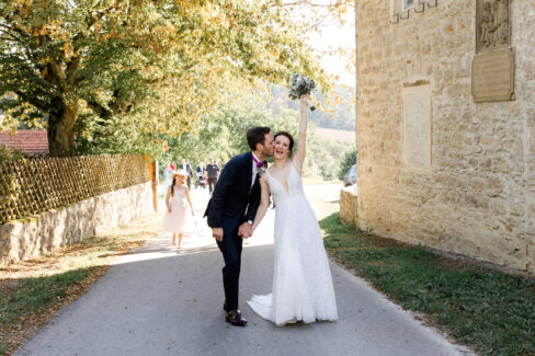 Jubelndes Hochzeitspaar auf dem Weg zur Party
