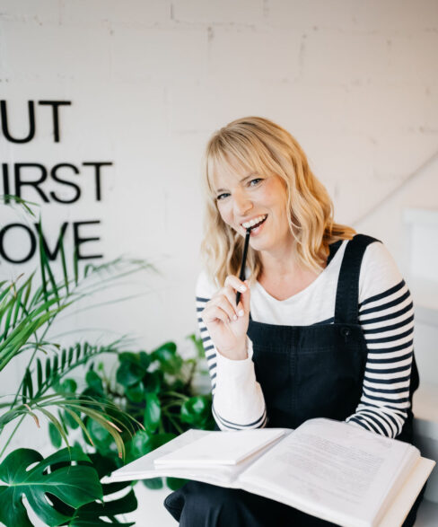 Traurednerin in blauer Latzhose und Ringelshirt kauend auf einem Bleistift.