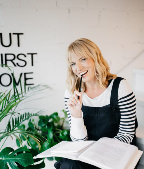 Traurednerin in blauer Latzhose und Ringelshirt kauend auf einem Bleistift.