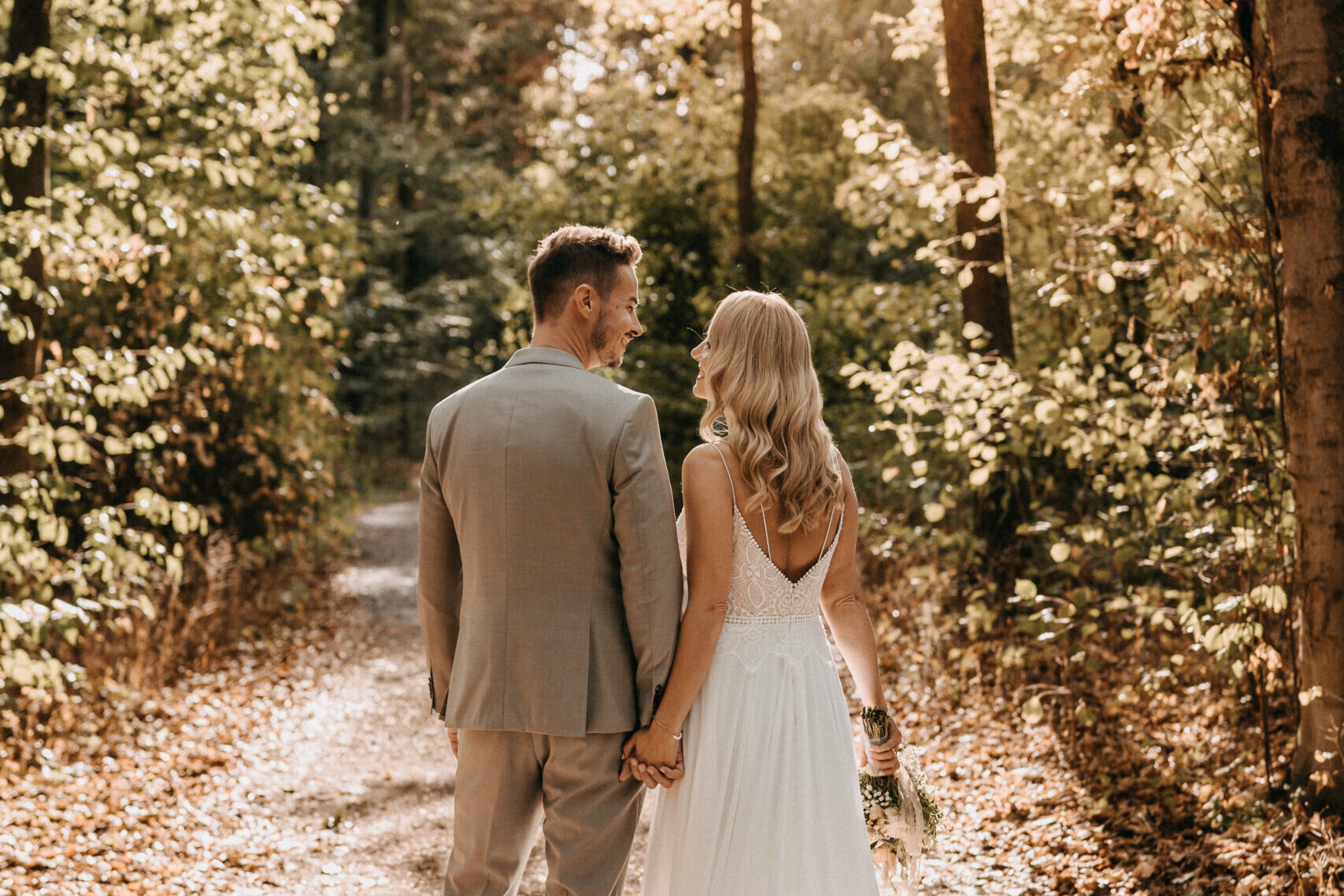 Jutta-Mesch-Fein.Klang.Momente Hochzeitsfotoshooting, Brautpaar mit Blick in den Wald mit Rückenansicht