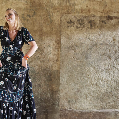 Jutta Mesch I tanzend vor einer Wand im Industrial Look mit Gitarre in der Ecke angelehnt