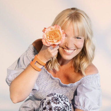 Sängerin mit einzelner orangefarbener Rose vor dem Auge im Blau weißen Kleid