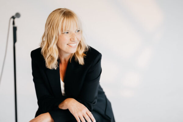 Jutta Mesch Sängerin mit Mikrofonständer im Hintergrund