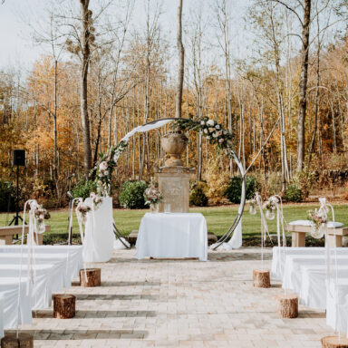 Setting einer freien Trauung mit Traubogen im Mittelpunkt