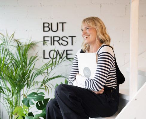 Jutta Mesch sitzt auf Treppe mit Traurednermappe